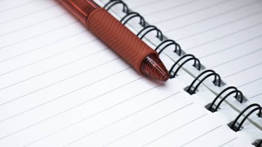 Satır defterini ve kırmızı kalemi kapat. Spiral not defteri kağıdı arkaplanı. 