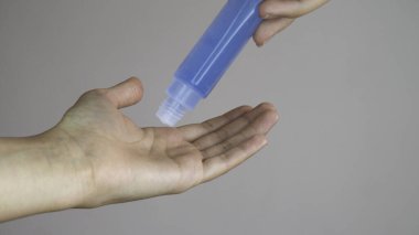Mikrop, bakteri ve virüs yayılmasını önlemek için alkol jeli uygulayan bir kadın eli. Kişisel hijyen kavramı.