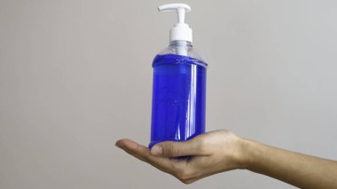  Bir kadının elindeki jel pompasını sterilize et..