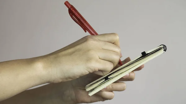 Mãos Femininas Segurar Uma Caneta Vermelha Tomar Notas Pequeno Caderno — Fotografia de Stock