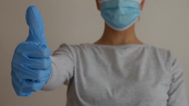 Eldivenli ve tıbbi maskeli bir kadın onay veriyor..