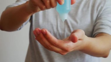  Elindeki temiz plastik şişeden alkol jeli sürüyorum. Anti mikrop ve önleyici konsept.