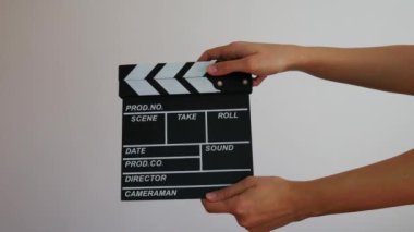 Gri arka planda izole edilmiş, el ele tutulan dişi ahşap klasör. Sinematografi üretim konsepti. Alan reklamlarını kopyala. 