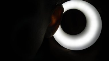 Soyut - Koyu LED ışık yüzüklü insan kulağı.