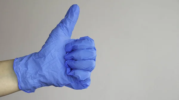 Mão Esquerda Luva Azul Mostrando Polegares Para Cima Espaço Negativo — Fotografia de Stock