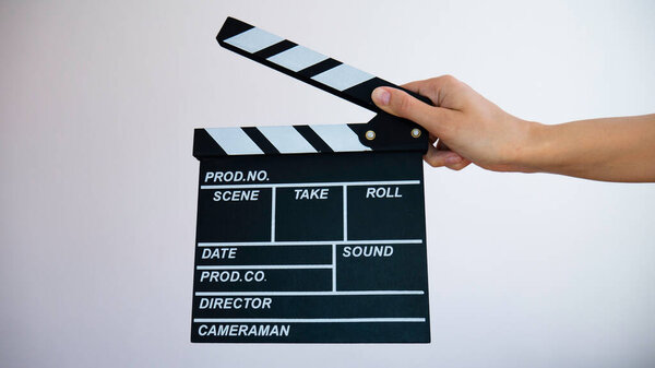 Hands holding clapperboard isolated on white background.