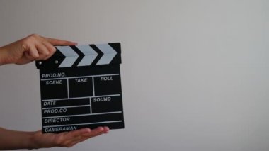 Kadınları yakın tut ahşap yönetmen temiz boş siyah film klasörü gri arka planda izole ediyor. 