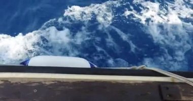 Hareket halindeki bir teknenin kenarından sarkan beyaz bir şamandıraya yakın çekim