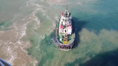 Büyük bir gemi demirli bir römorkör çekiyor - Cartagena limanı, İspanya, Mayıs 2019