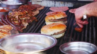 Çeşitli et türleri ızgara. Yemek festivalinde hamburger, sosis ve et hazırlığı.