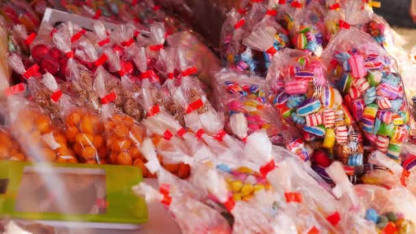 通りの販売で袋にカラフルで多様なお菓子を詰め — ストック動画