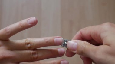 Tırnaklarını kesmek için tırnak makası kullanan bir kadının yakın çekimi..