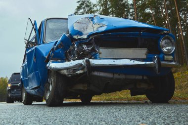 Kaza yerindeki otoyolda hasar görmüş eski bir araba.