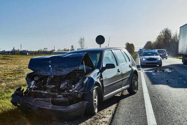Güneşli bir günde yol kenarında hasarlı bir araba.