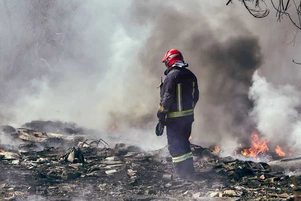 30 Mart 2020, Riga, Letonya: Yasadışı çöplükteki yangını söndüren itfaiyeci