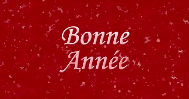 Šťastný nový rok text ve francouzštině "Bonne annee" tvoří z prachu a obraty na prach vodorovně na červeném animované pozadí — Stock video