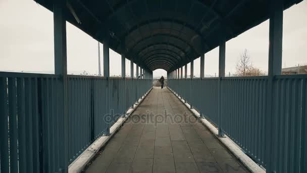 Man running away through the footbridge — Stock Video