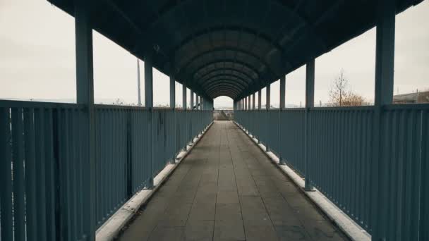 Coppia che corre mano a mano attraverso il ponte pedonale sull'autostrada — Video Stock