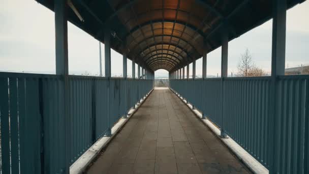 Άνθρωπος με μπεζ παλτό που τρέχει πέρα από την πεζογέφυρα πάνω στον αυτοκινητόδρομο — Αρχείο Βίντεο