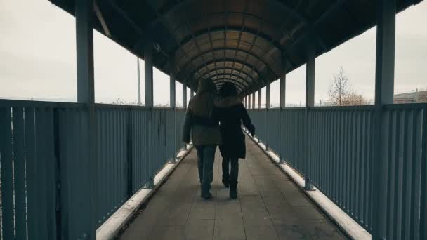 Casal caminhando e abraçando através da passarela sobre a estrada — Vídeo de Stock