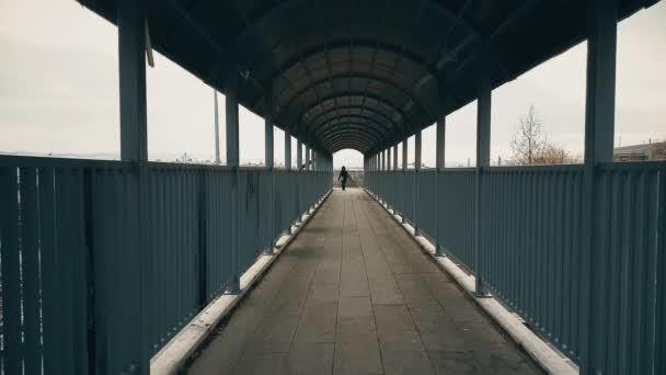 Vrouw met zwarte jas lopen over de voetgangersbrug over de snelweg — Stockvideo