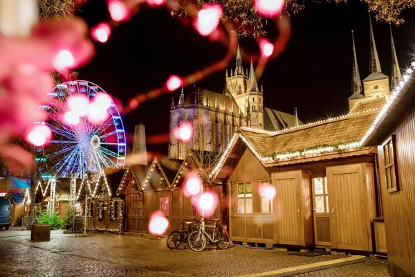 ぼやけた光で要約お祝いの写真。クリスマスマーケット、観覧車、夜の有名な大聖堂ドムの丘。ドイツのエアフルト — ストック写真