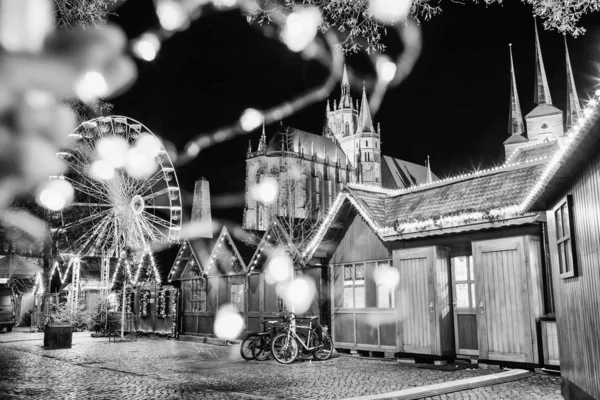 ぼやけた光で要約お祝いの写真。クリスマスマーケット、観覧車、夜の有名な大聖堂ドムの丘。ドイツのエアフルト。黒と白 — ストック写真