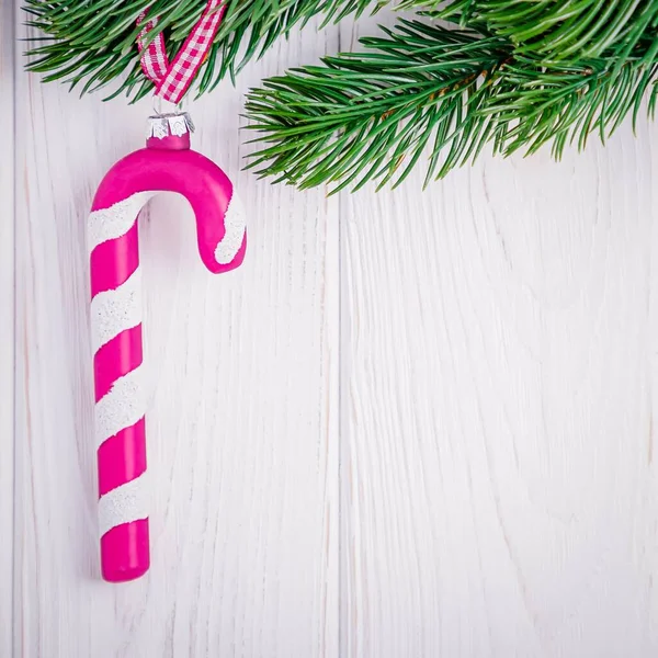 Decorações de Natal rosa magenta vidro doce cana e ramo de árvore de natal em um fundo branco. Espaço de cópia — Fotografia de Stock
