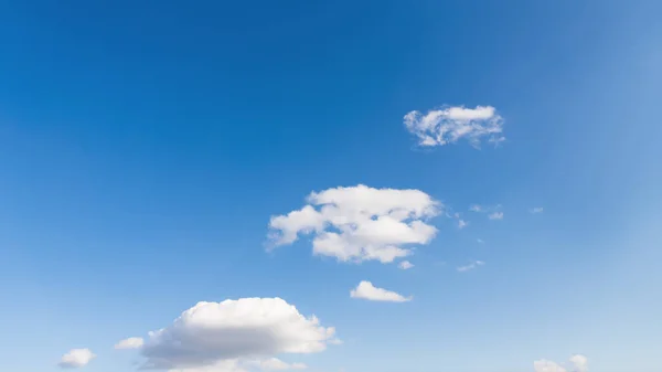 Pequenas nuvens em um fundo azul gradiente céu. As nuvens sobem, 16: 9. — Fotografia de Stock