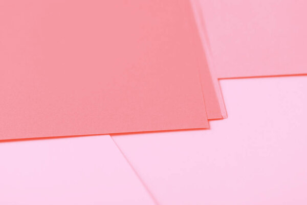 Sheets of paper. Geometric background, shades of pink and coral
