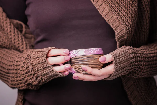 Vacker kvinnlig hand Holding Brown Clay Texture Cup. Manikyr med rosa nagellack. Mysigt koncept — Stockfoto