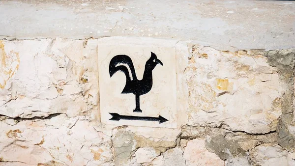 Arrow pointer with black cock on the way to Church of Saint Peter in Gallicantu, located on Mount Zion, Jerusalem, Israel, 16:9 panoramic format