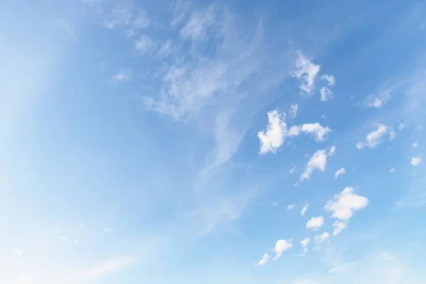 Белые небольшие мягкие пушистые облака на бледно-голубом фоне неба — стоковое фото