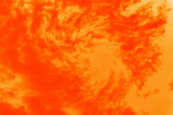 Lush lava hot orange color sky with cirrocumulus clouds. Whirlpool, funnel or swirl effect