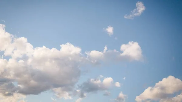 Vackra vita mjuka fluffiga moln på en blek blå himmel bakgrund, 16: 9 panoramaformat — Stockfoto