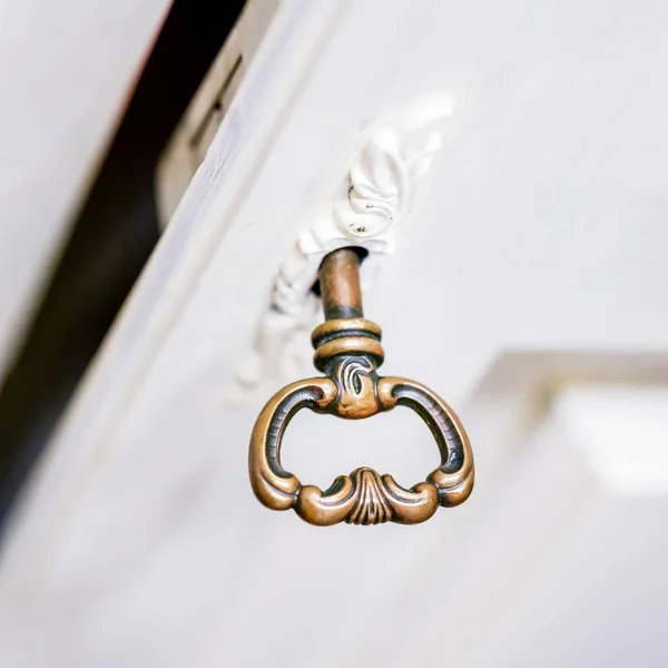 Una llave vieja en el ojo de la cerradura. Llave en puerta de madera blanca —  Fotos de Stock