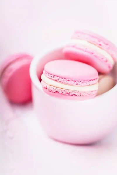 Homemade french dessert pink macaroons or macarons on pink background, copy space