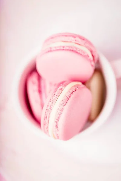 Homemade french dessert pink macaroons or macarons on pink background, copy space