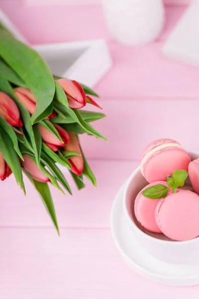 Macarons ou macarons roses dessert français maison et tulipes printanières sur fond rose, espace de copie — Photo