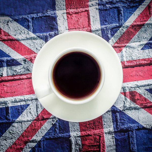 White cup of black coffee and British flag Union Jack