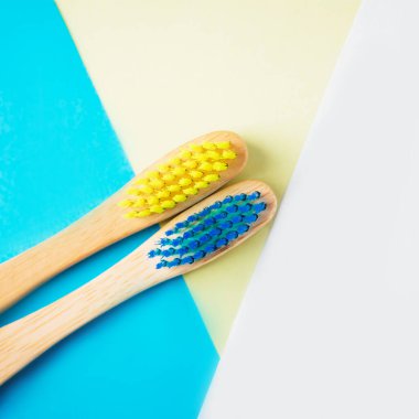 Sarı ve mavi bambu diş fırçaları. Çevre dostu kavramı. Çok az. Kopya alanı, trendy geometrik arka plan