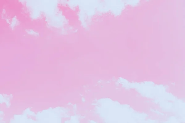 Pink sky background with soft delicate white clouds. Copy space