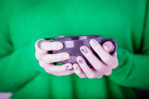 Hermosas Manos Femeninas Sosteniendo Taza Negra Sobre Fondo Verde Brillante — Foto de Stock