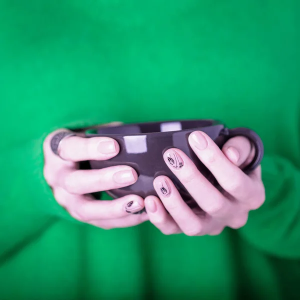 Hermosas Manos Femeninas Sosteniendo Taza Negra Sobre Fondo Verde Brillante — Foto de Stock