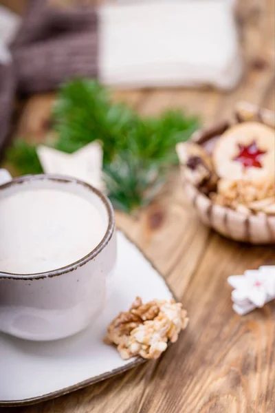 Christmas mood. White cup of coffee cappuccino and homemade cookies, blurred background, soft focus