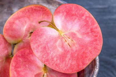 Gri arka planda pembe ve kırmızı kanlı elmalar. Pembe etli elmalar.