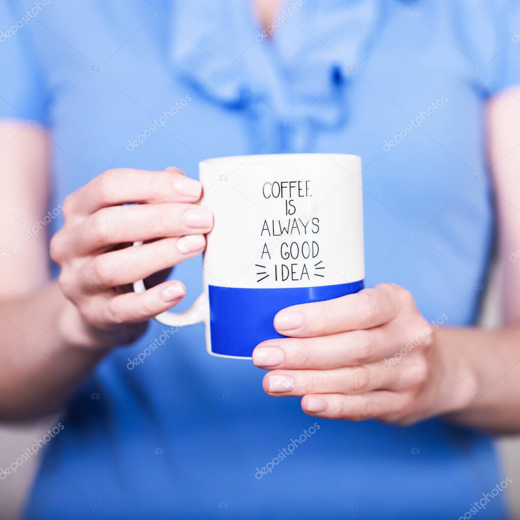 Female hands holding cup with inscription. Coffee is always a good idea. Break time concept