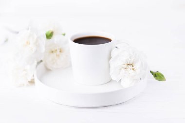Beyaz arka planda bir fincan sade kahve ve karanfil çiçeği. Boşluğu kopyala