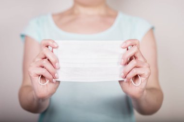 Beyaz tıbbi maske tutan kadın elleri. Boşluğu kopyala