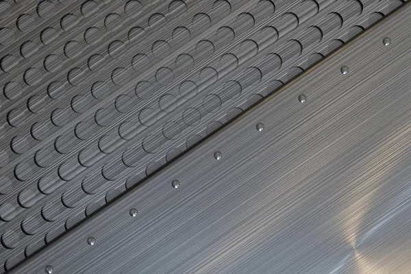 Прямоугольная металлическая пластина с заклепками на круглой решетке — стоковое фото